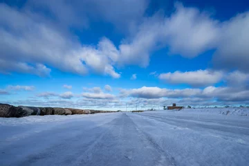 Fotobehang Beautiful snowy road in winter under blue sky © Alex V
