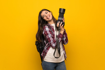 Photographer teenager girl over yellow wall