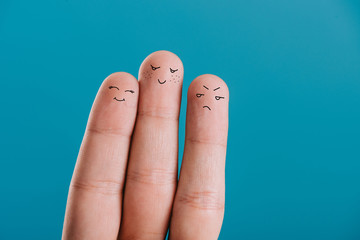 partial view of fingers with different emotions isolated on blue