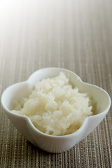 Sticky rice in white bowl on brown asian styled mat and space for write wording, Tradition food of Thai north eastern people, sold in market and restaurant