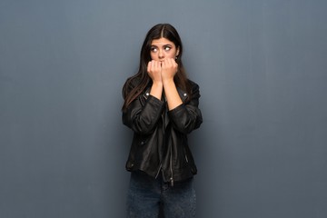 Fototapeta premium Teenager girl over grey wall nervous and scared putting hands to mouth