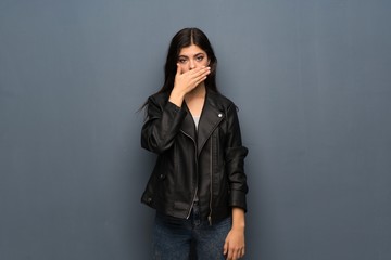Teenager girl over grey wall covering mouth with hands for saying something inappropriate