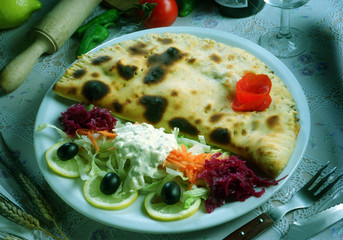 Pizza calzone junto a una ensalada.