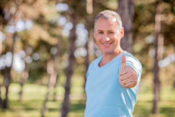 Happy mature business man showing thumbs up sign