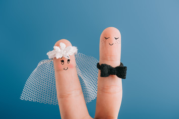 cropped view of happy wedding couple of fingers isolated on blue