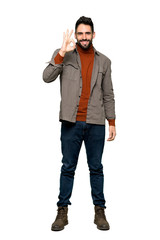 Fototapeta premium Full-length shot of Handsome man with beard showing an ok sign with fingers on isolated white background