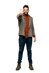 Fototapeta premium Full-length shot of Handsome man with beard smiling and showing victory sign on isolated white background