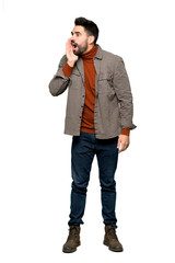 Full-length shot of Handsome man with beard shouting with mouth wide open to the lateral on isolated white background
