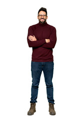 Naklejka premium Full-length shot of Handsome man with glasses keeping the arms crossed in frontal position on isolated white background