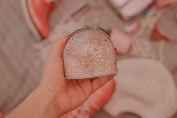 Toned image of snow globe in girl’s hand with messy flat lay on background