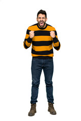 Full-length shot of Handsome man with striped sweater frustrated by a bad situation on isolated white background