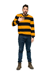 Full-length shot of Handsome man with striped sweater surprised and shocked while looking right on isolated white background