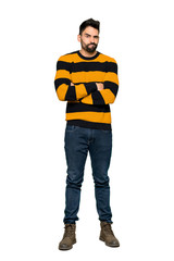 Fototapeta premium Full-length shot of Handsome man with striped sweater feeling upset on isolated white background
