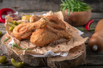 Juicy, crispy fried chicken leg for take away or food delivery  on wooden background, rustic style. Fast food 