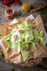 Healthy vegetarian salad from peking cabbage with walnut  on a wooden background, rustic style.