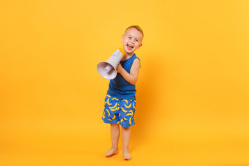 Kid boy 3-4 years old in blue beach summer clothes hold speak in megaphone isolated on bright yellow orange background children studio portrait. People childhood lifestyle concept Mock up copy space.