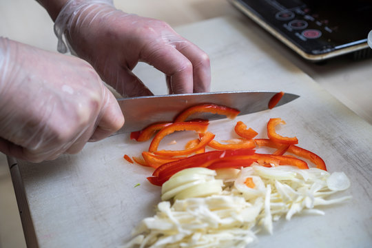 Chef cuts the vegetables into a meal. Preparing dishes. A man uses a knife and cooks.