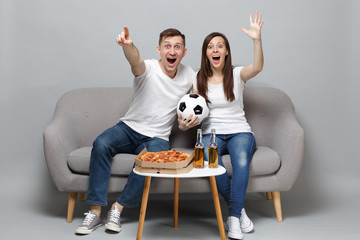 Excited fun couple woman man football fans in white t-shirt cheer up support favorite team with...