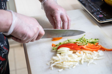 Chef cuts the vegetables into a meal. Preparing dishes. A man uses a knife and cooks.