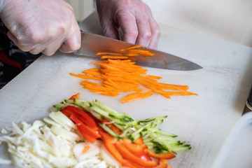 Chef cuts the vegetables into a meal. Preparing dishes. A man uses a knife and cooks.