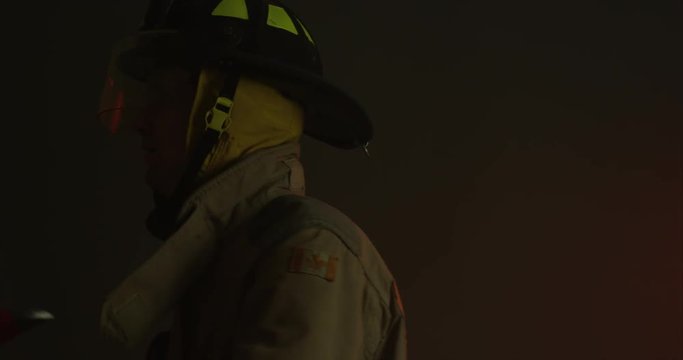 Firefighter swinging axe - side profile slow motion