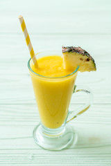 fresh pineapple smoothie glass on wood table