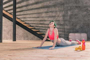 Young woman with bright green hair stretching after gym