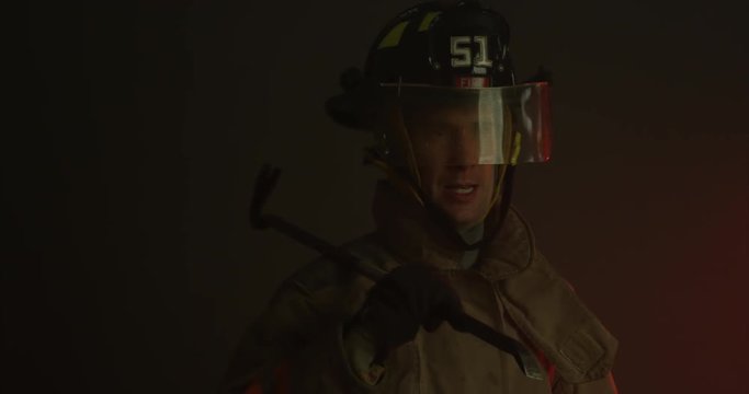 Firefighter holding crowbar on shoulder - medium shot