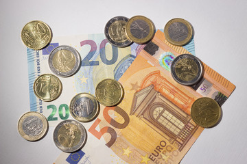 coins are on paper money lies on a white background