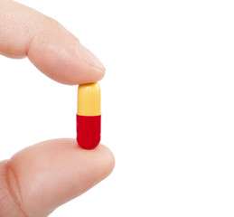 Hand holding  a pill. Cut out.