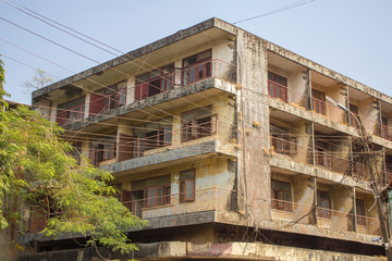 electricity street wires on the background of an old yellow shabby asian low-rise house