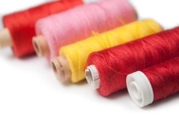 closeup of sewing thread spool bobbins on white background