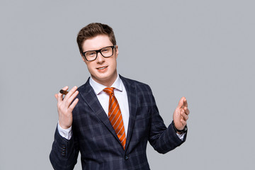 successful stylish handsome businessman with cigar isolated on grey