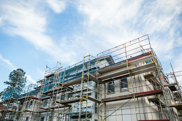 Construction building in the city against blue sky with clouds.