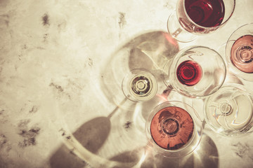 Wine tasting concept - glass with different wine on marble background, top view