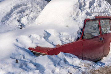 Car covered with snow in the spring