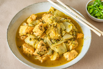 Chicken with cabbage and curry sauce in a large bowl and chopsticks - Thai cuisine