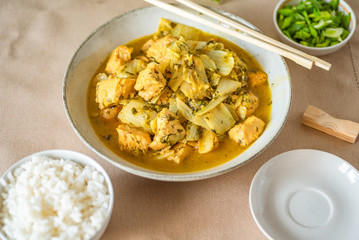 Chicken with cabbage in a curry sauce in a large bowl and a cup of rice, chopsticks - Japanese cuisine