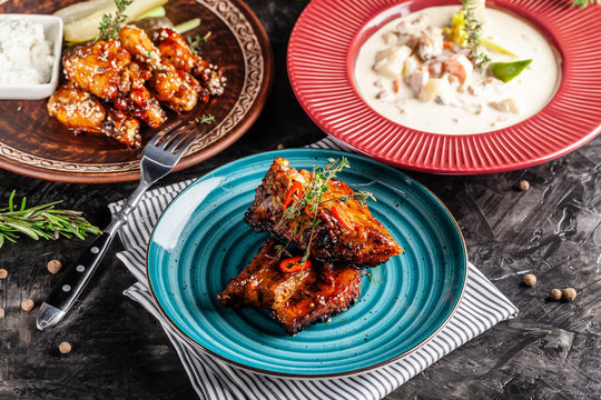 The concept of American cuisine. American dishes on the table. Meat, soup, glazed chicken wings. Background image. copy space