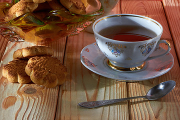 A lone cup of tea on the kitchen table in bright and warm sunshine.