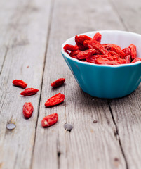 goji berries in a bowl on wooden background