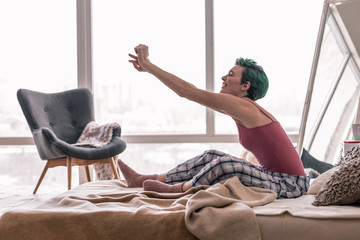 Happy woman stretching her body while waking up in the morning
