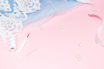Tulle with lace and garment on a pink background. Sewing a wedding dress concept.