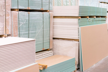 Gypsum plasterboard in the pack. The stack of gypsum board preparing for construction. Pallet with plasterboard in the building store. Construction Materials. Drywall warehouse - obrazy, fototapety, plakaty