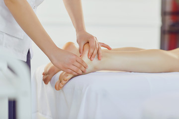 Fototapeta na wymiar Therapist massaging feet of client lying