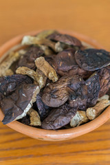 dried mushrooms boletus sliced, on a plate, on an old wooden background. Composition of dried mushrooms and plate on wooden background. vertical photo