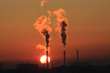 Factory smoke at sunset sky