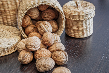 Walnuts in basket on a dark wooden table
