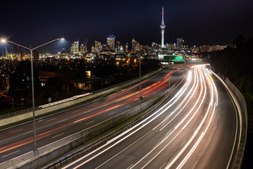 Fototapeta na wymiar Car light trails at night heading into Auckland, with the city skyline