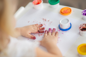 the child draws finger paints close-up of the hand in white